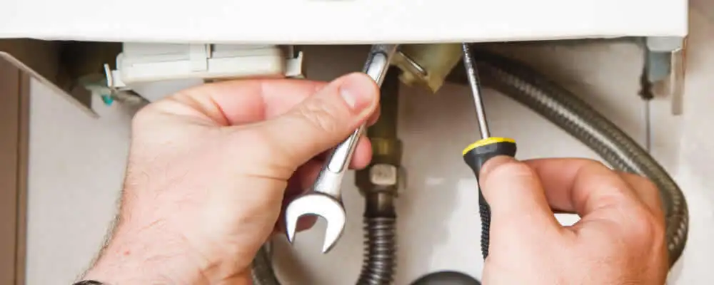 Boiler repair technician tightening pipe fittings and connections in Charlotte, NC