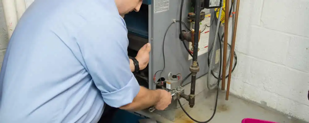 Furnace repair technician inspecting and servicing a home heating system in Charlotte, NC