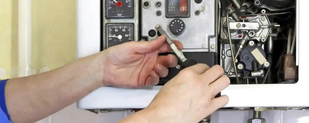 Heating repair technician adjusting boiler controls and components in Charlotte, NC