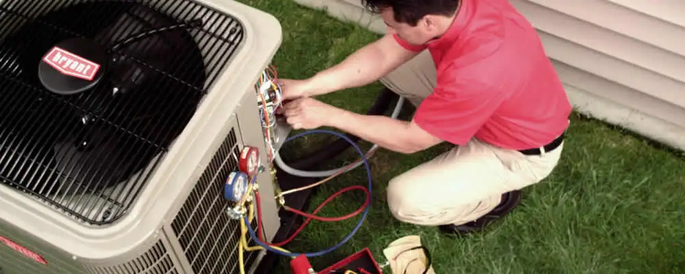 HVAC technician servicing an outdoor air conditioner unit in Charlotte, NC