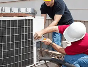 HVAC technicians repairing an outdoor AC unit on a rooftop in Charlotte, NC