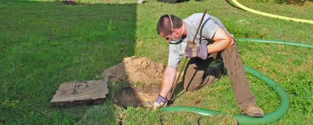 Septic pumping technician servicing a residential septic tank in Charlotte, NC