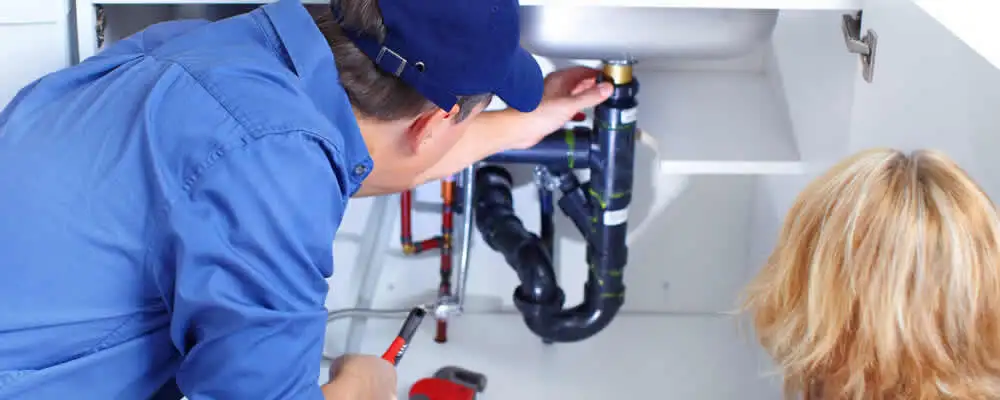 Plumber repairing under-sink drain pipes and fittings in Charlotte, NC